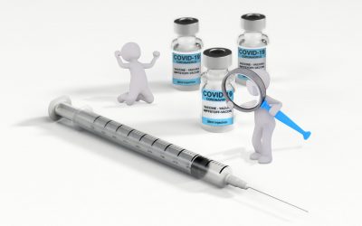 Spritze mit drei Fläschchen Impfstoff gegen Covid-19